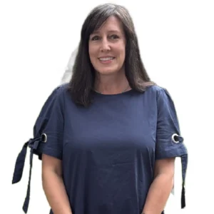 Woman in blue shirt, smiling, white background.